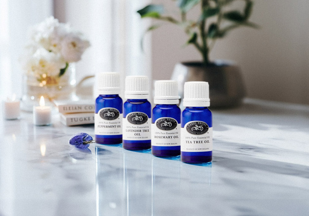 Image showcasing four pure essential oils - tea tree, lavender, peppermint, and rosemary - from Carol Priest's aroma line.
