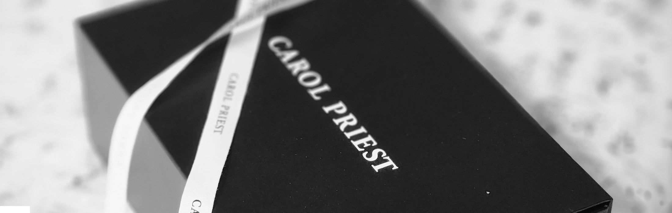 Carol Priest's brand logo beautifully engraved on a luxury gift box, embodying the brand's commitment to refined quality.